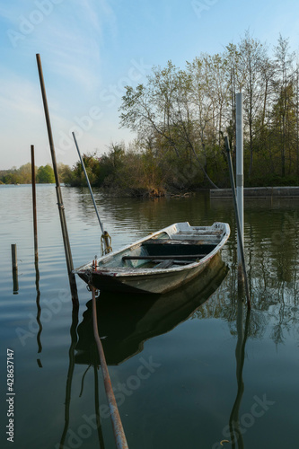 Fototapeta Naklejka Na Ścianę i Meble -  Abandoned rowing boat, isolated on a lake. Wooden rowboat on water.