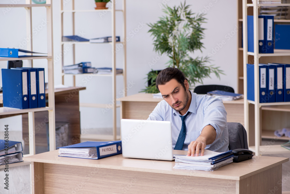 Young male bookkeeper working in the office Young male bookkeeper working in the office