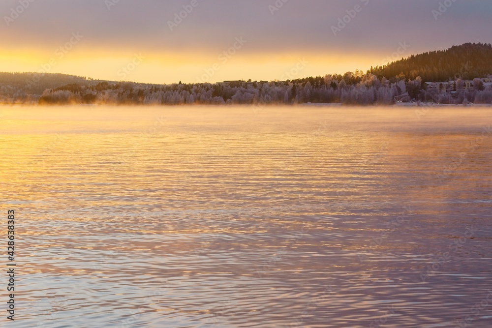 Steaming Lake Storsjön in the light of sunset in late autumn