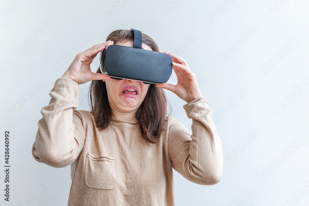 Smile young woman wearing using virtual reality VR glasses helmet headset on white background. Smartphone using with virtual reality goggles. Technology, simulation, hi-tech, videogame concept. Smile young woman wearing using virtual reality VR glasses helmet headset on white background. Smartphone using with virtual reality goggles. Technology, simulation, hi-tech, videogame concept.