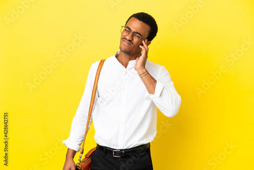 African American business man over isolated yellow background with headache