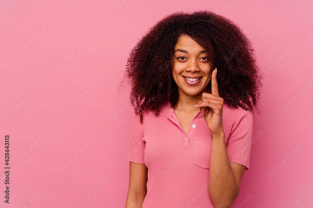 Young african american woman isolated on pink background showing number one with finger. Young african american woman isolated on pink background showing number one with finger.