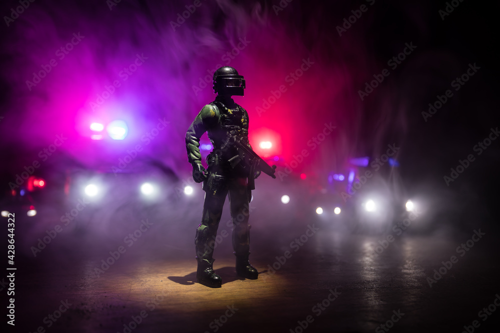 Fototapeta premium Anti-riot police give signal to be ready. Government power concept. Police in action. Smoke on a dark background with lights. Blue red flashing sirens. Dictatorship power