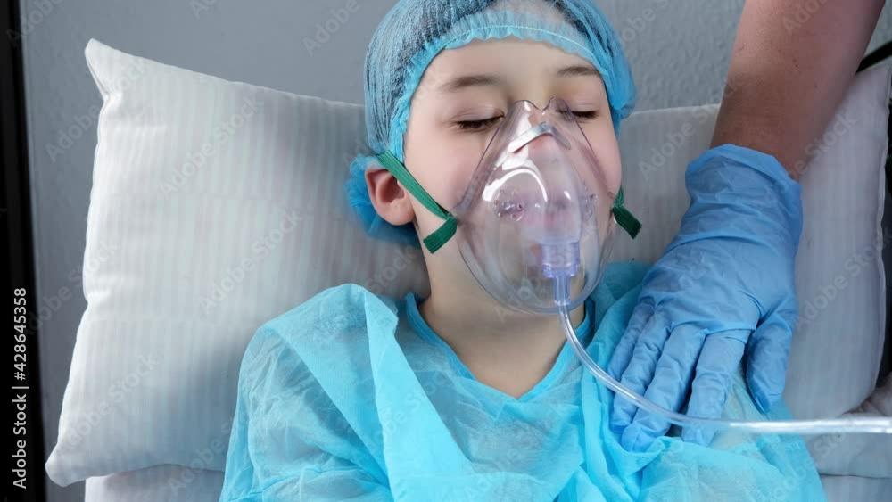 little patient in shirt, child, boy lies, facial oxygen mask, concept of medical care, anesthesiology and intensive care, oxygen therapy, treatment of coronavirus, COVID-19
