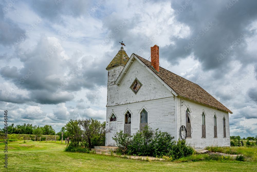 Dramatic sky over the historic yet abandoned Trossachs United Church in Trossachs, SK