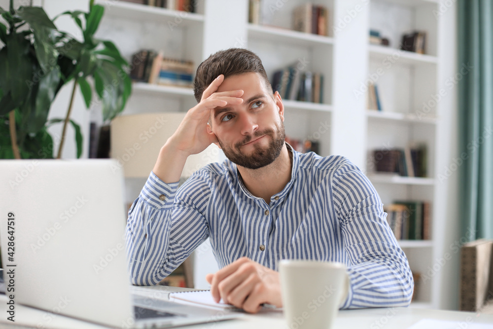 Happy young business man is analizing financial documents from home during self isolation. Happy young business man is analizing financial documents from home during self isolation.