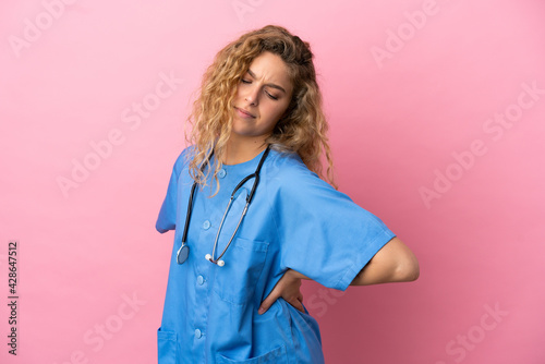 Young surgeon doctor woman isolated on pink background suffering from backache for having made an effort