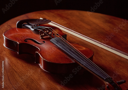 Violin in retro style and bow on wooden table