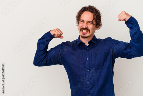 Young caucasian man isolated on white background raising fist after a victory, winner concept.