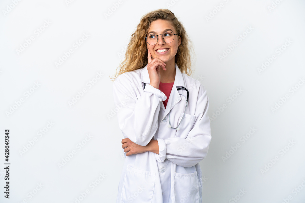 Young doctor blonde woman isolated on white background thinking an idea while looking up