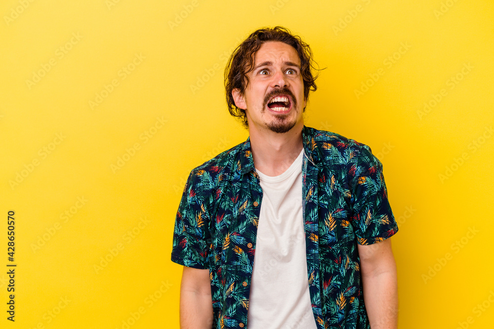 custom made wallpaper toronto digitalYoung caucasian man isolated on yellow background shouting very angry, rage concept, frustrated.