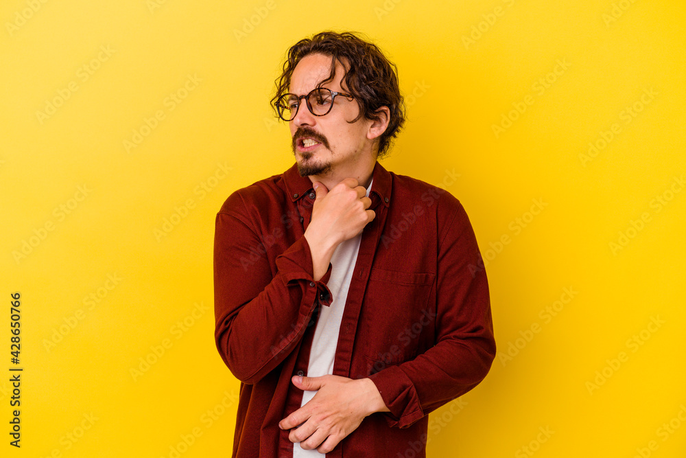 Young caucasian man isolated on yellow background suffers pain in throat due a virus or infection. Young caucasian man isolated on yellow background suffers pain in throat due a virus or infection.