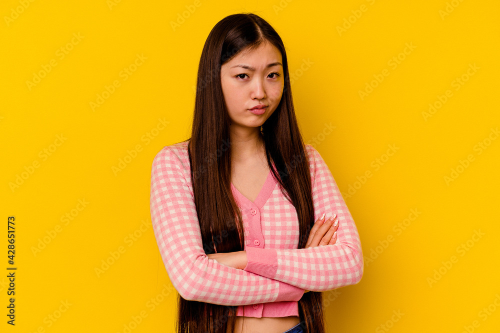 Young chinese woman isolated on yellow background suspicious, uncertain, examining you. Young chinese woman isolated on yellow background suspicious, uncertain, examining you.