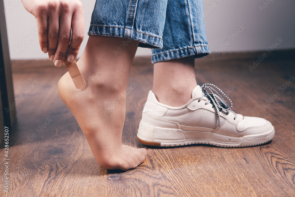 Woman's heel with medical adhesive plaster from calluses during wearing a new shoe Woman's heel with medical adhesive plaster from calluses during wearing a new shoe