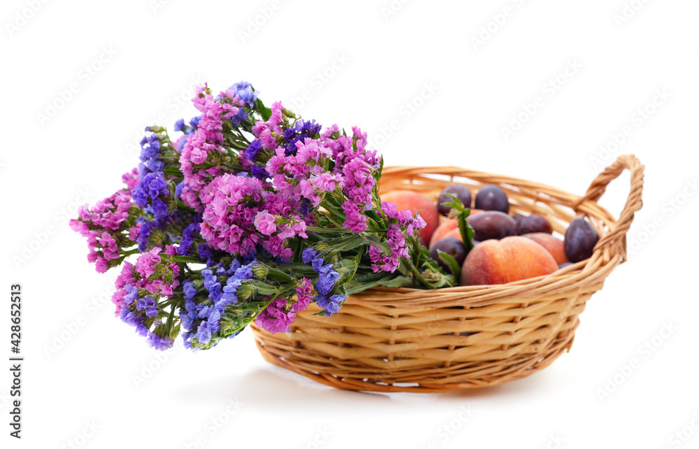 Colorful static in the basket with peaches and plums.