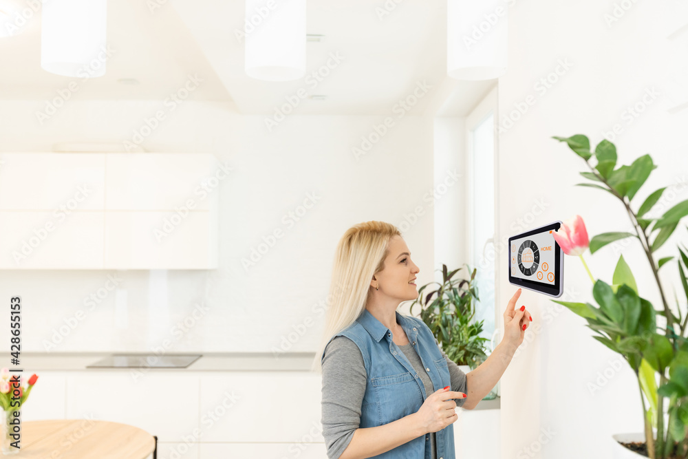 Young woman using application of smart home automation Young woman using application of smart home automation