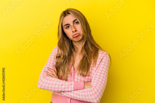 Young blonde caucasian woman isolated on yellow background who is bored, fatigued and need a relax day.