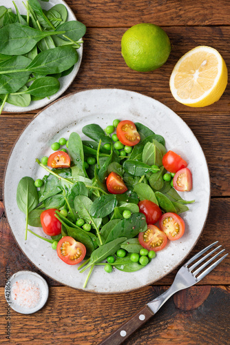 Healthy detox salad with baby spinach and cherry tomatoes. Weight loss, dieting concept. Table top view