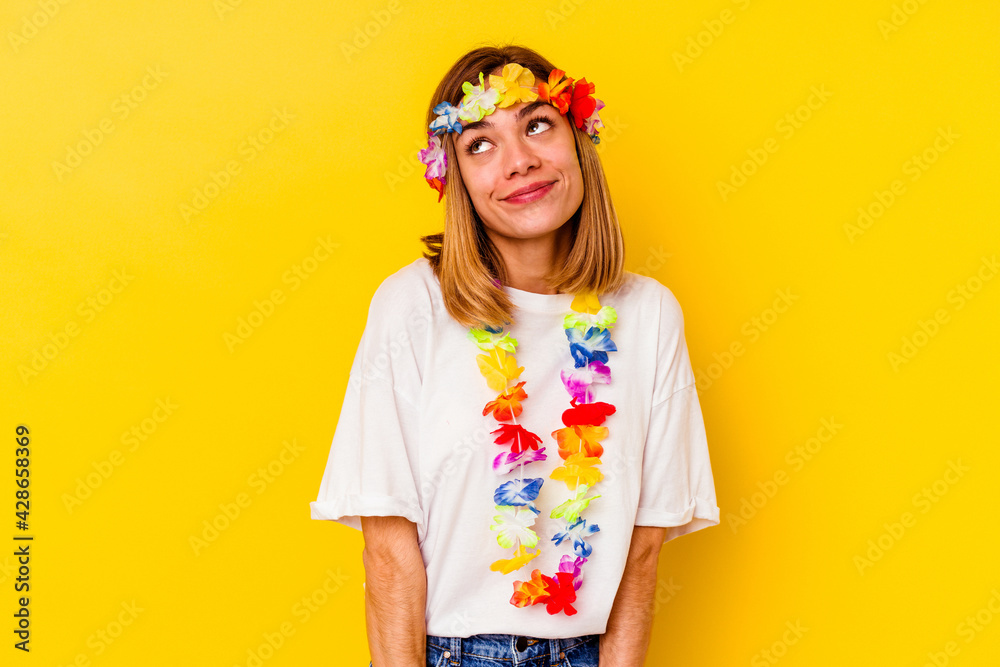 Young caucasian woman celebrating a hawaiian party isolated on yellow background dreaming of achieving goals and purposes