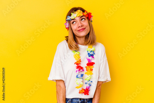 Young caucasian woman celebrating a hawaiian party isolated on yellow background dreaming of achieving goals and purposes