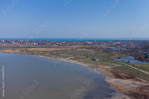 A stone spit and wooden pillars on the surface of the Kuyalnik estuary. Helicopter view.