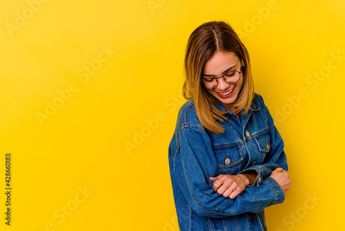 Young caucasian skinny woman isolated on yellow background smiling confident with crossed arms. © Asier