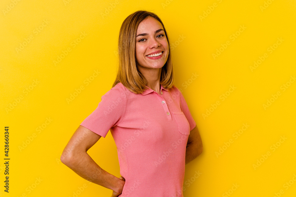 Young caucasian skinny woman isolated on yellow background confident keeping hands on hips.