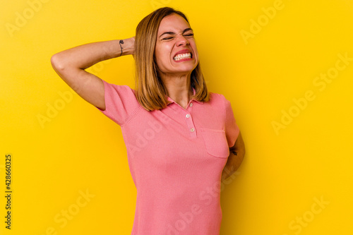 Young caucasian skinny woman isolated on yellow background suffering neck pain due to sedentary lifestyle.