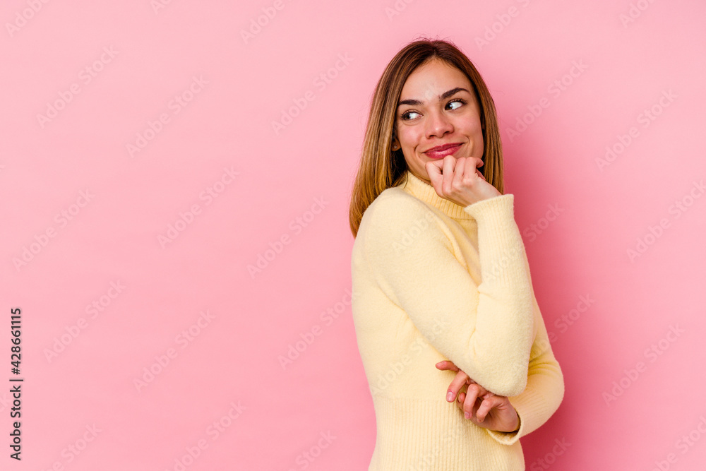 Young caucasian woman isolated on pink background relaxed thinking about something looking at a copy space. Young caucasian woman isolated on pink background relaxed thinking about something looking at a copy space.