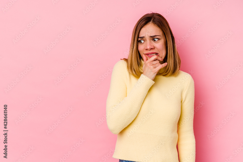 Young caucasian woman isolated on pink background touching back of head, thinking and making a choice. Young caucasian woman isolated on pink background touching back of head, thinking and making a choice.