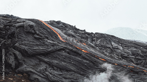 Hot lava pouring down the lava field creating strange shapes. photo