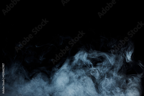 Abstract white smoke moves on black background. Beautiful swirling gray smoke.