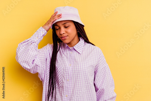 Young african american woman isolated on yellow background touching temples and having headache. © Asier
