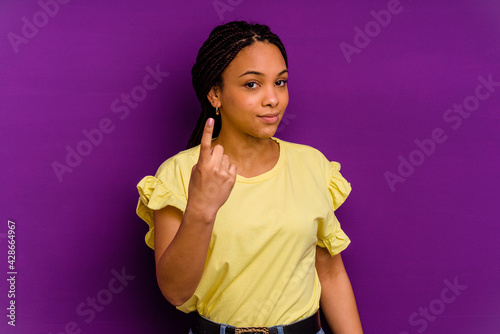 Young african american woman isolated on yellow background Young african american woman isolated on yellow background pointing with finger at you as if inviting come closer.