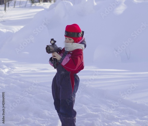 preschool girl, in overalls, examines a weapon, playing laser tag