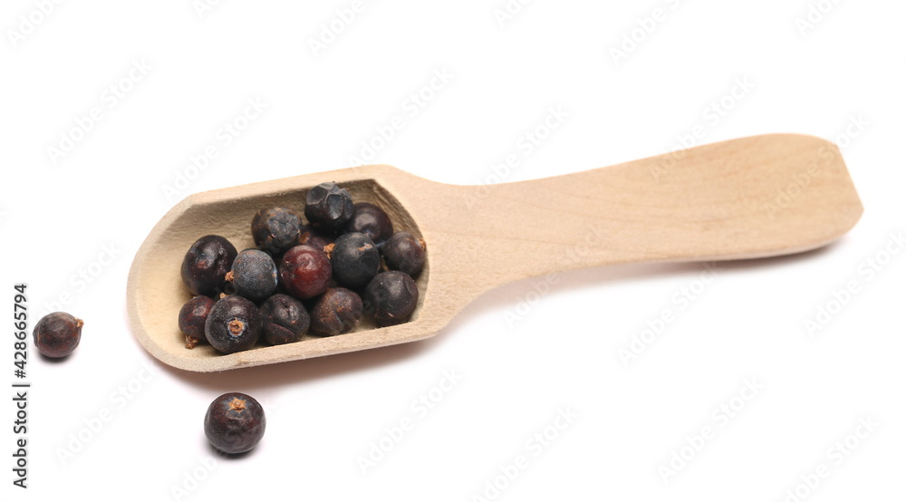 Dried juniper berry in wooden spoon isolated on white background