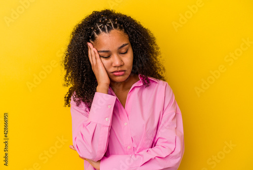 Young african american woman isolated on yellow background who is bored, fatigued and need a relax day.