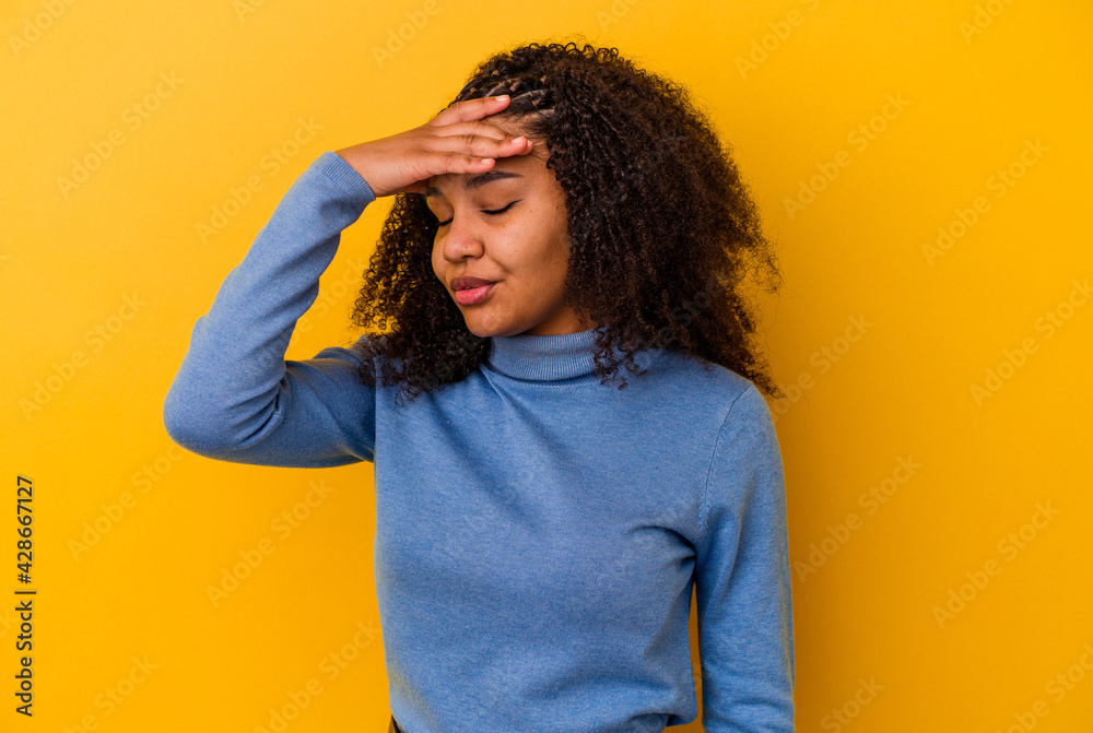 Young african american woman isolated on yellow background touching temples and having headache. Young african american woman isolated on yellow background touching temples and having headache.