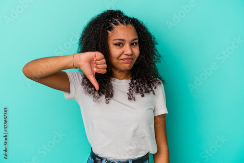 Young african american woman isolated on blue background showing thumb down  disappointment concept.