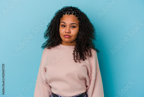 Young african american woman isolated on blue background sad, serious face, feeling miserable and displeased.