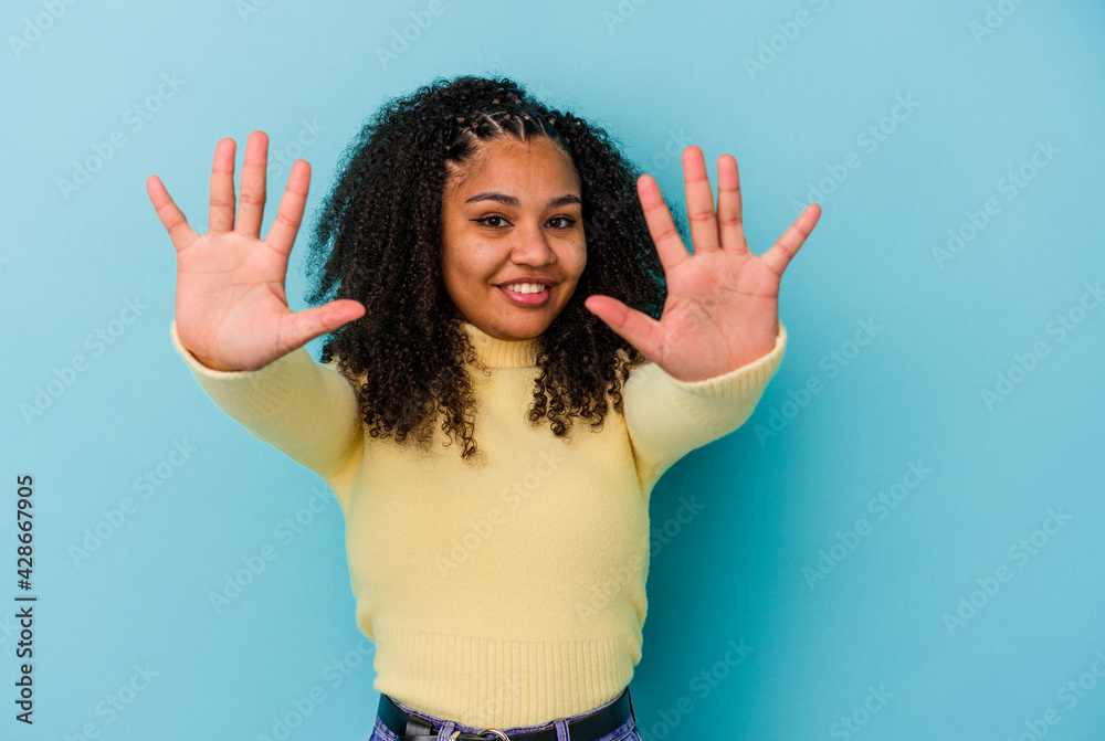 Young african american woman isolated on blue background showing number ten with hands. Young african american woman isolated on blue background showing number ten with hands.