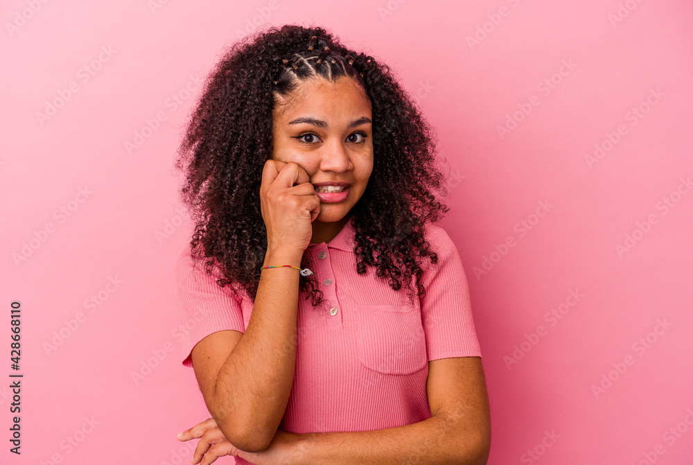 Young african american woman isolated on pink background biting fingernails, nervous and very anxious. Young african american woman isolated on pink background biting fingernails, nervous and very anxious.