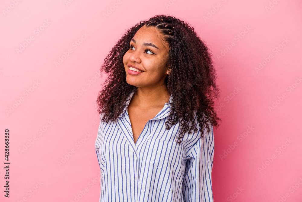 Young african american woman isolated on pink background relaxed and happy laughing, neck stretched showing teeth. Young african american woman isolated on pink background relaxed and happy laughing, neck stretched showing teeth.