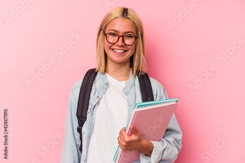 Young venezuelan student woman isolated on pink background happy, smiling and cheerful.