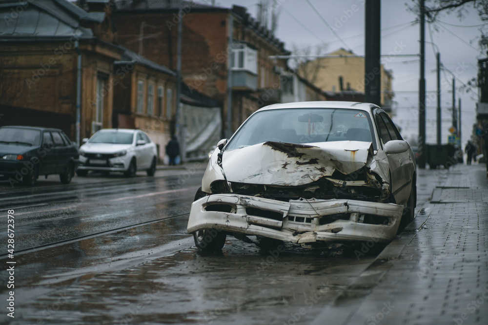 Auto accident on the street. A car damaged after a severe accident stands on a city street. Accident insurance concept.