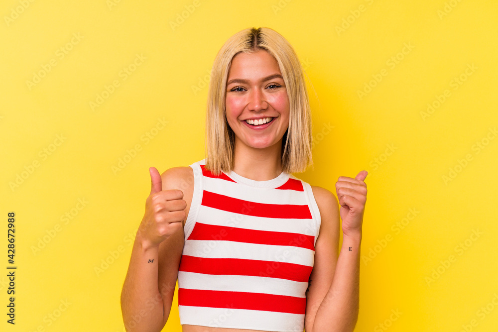 Young venezuelan woman isolated on yellow background raising both thumbs up, smiling and confident. Young venezuelan woman isolated on yellow background raising both thumbs up, smiling and confident.