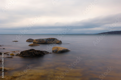 Long exposure horizontal photograph  sea horizon  Three large stones protruding from the water.