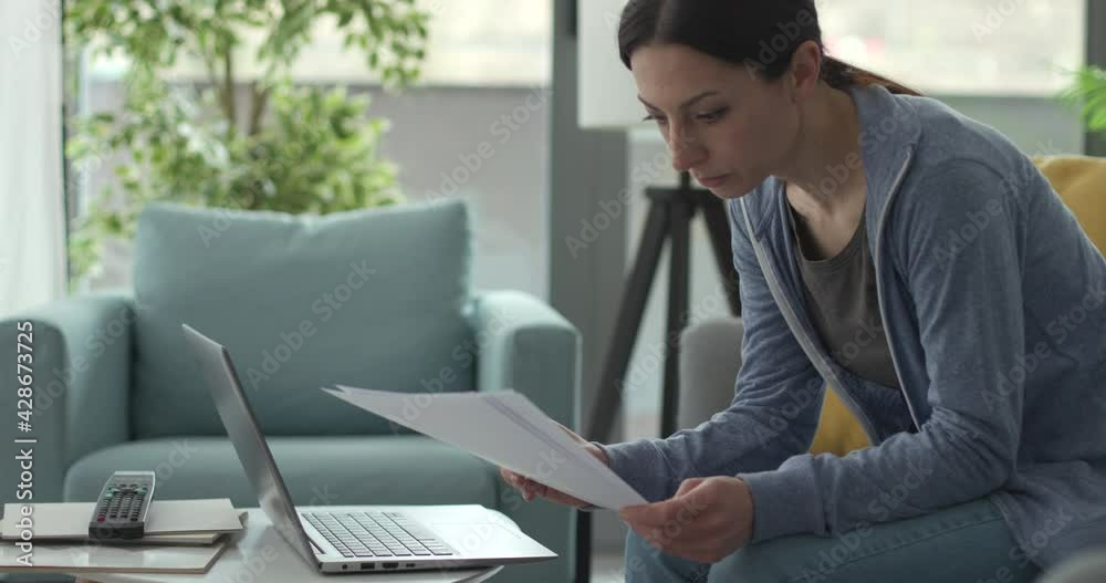 Woman working from home and checking paperwork Woman working from home and checking paperwork