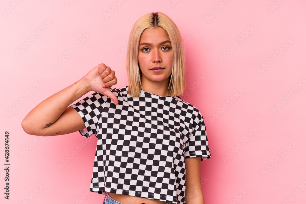 Young venezuelan woman isolated on pink background showing a dislike gesture, thumbs down. Disagreement concept. Young venezuelan woman isolated on pink background showing a dislike gesture, thumbs down. Disagreement concept.