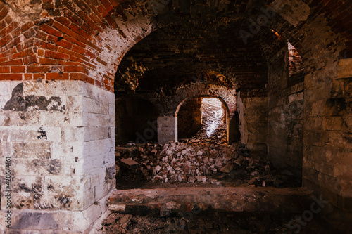 Old vaulted red brick cellar under abandoned building